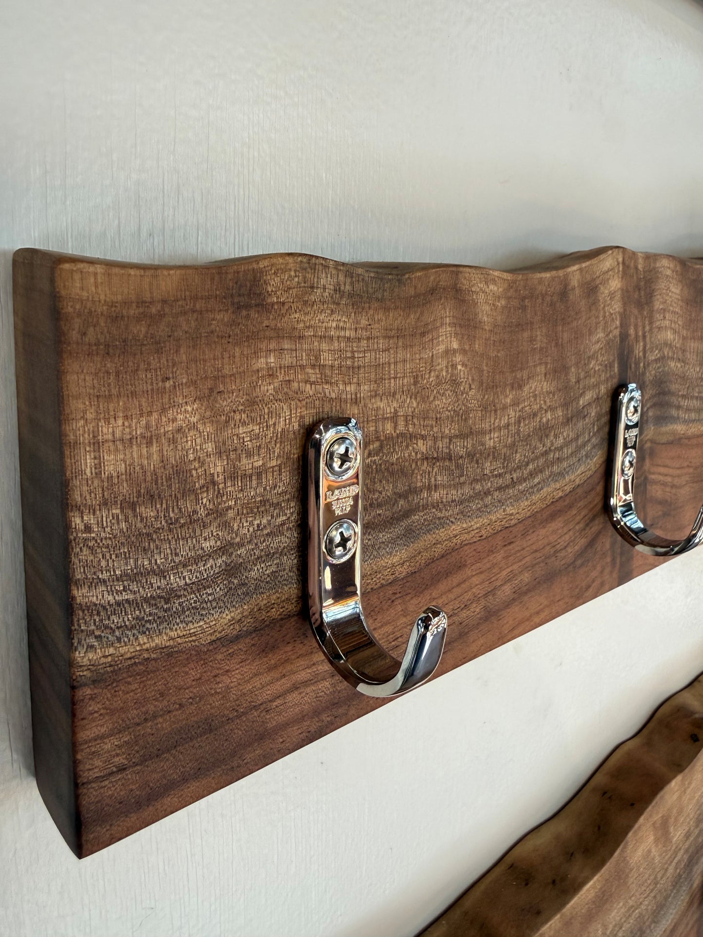 Wooden headboard with metal hooks on a neutral background