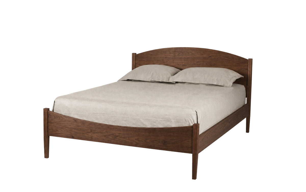 A classic wooden bed frame with a curved headboard and footboard, shown with light beige bedding and two pillows on a solid white background.