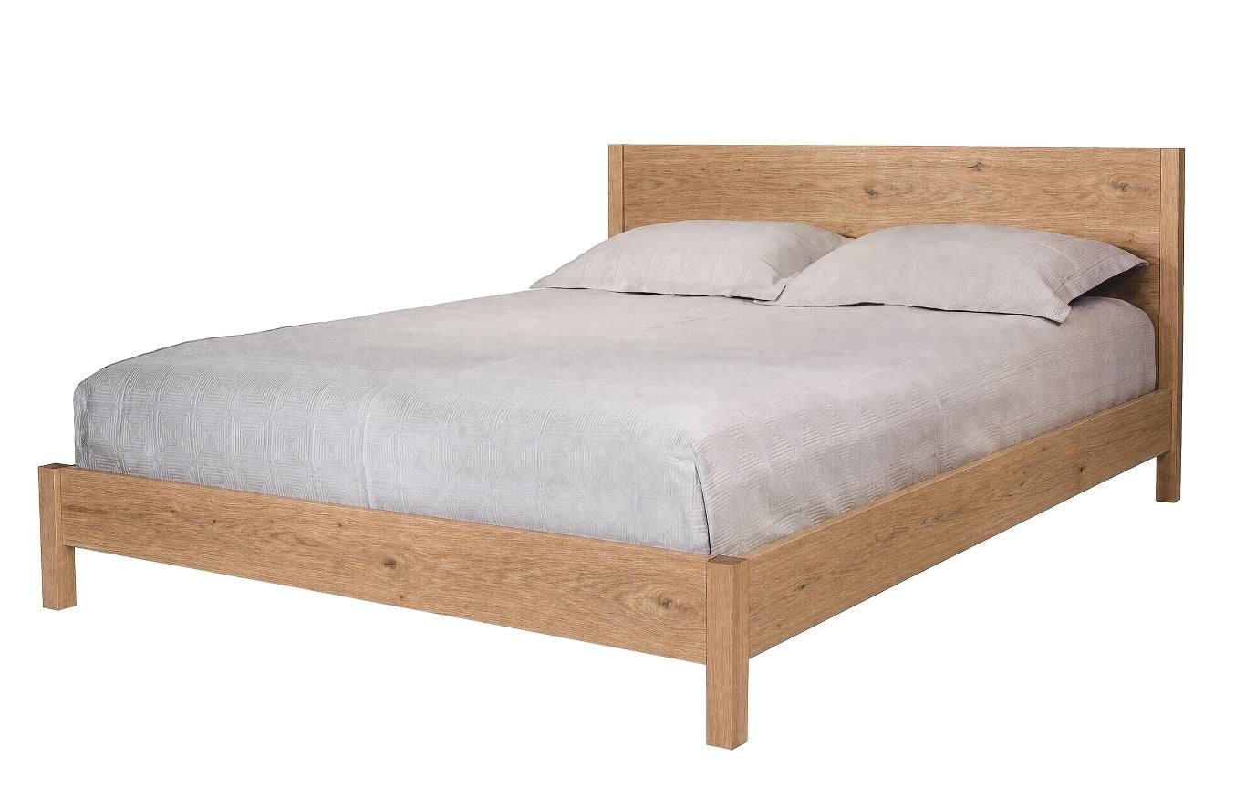A light oak wood platform bed frame with a matching headboard, styled with light gray bedding and two pillows, shown against a plain white background.