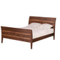 A dark Walnut wood bed frame with a curved headboard and footboard, shown with white bedding and two pillows against a solid white background.