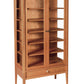 A mid-century modern wooden display cabinet with glass doors, multiple interior shelves, and a single drawer at the bottom, shown on a plain white background.