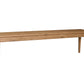 A long rectangular wooden bench with four legs, shown from a three-quarter angle on a solid white background.