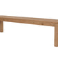A long rectangular wooden bench with a natural oak finish, featuring four sturdy legs, shown against a plain white background.