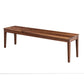 A long wooden bench with a medium brown finish and visible wood grain, shown from a three-quarters angle on a plain white background.