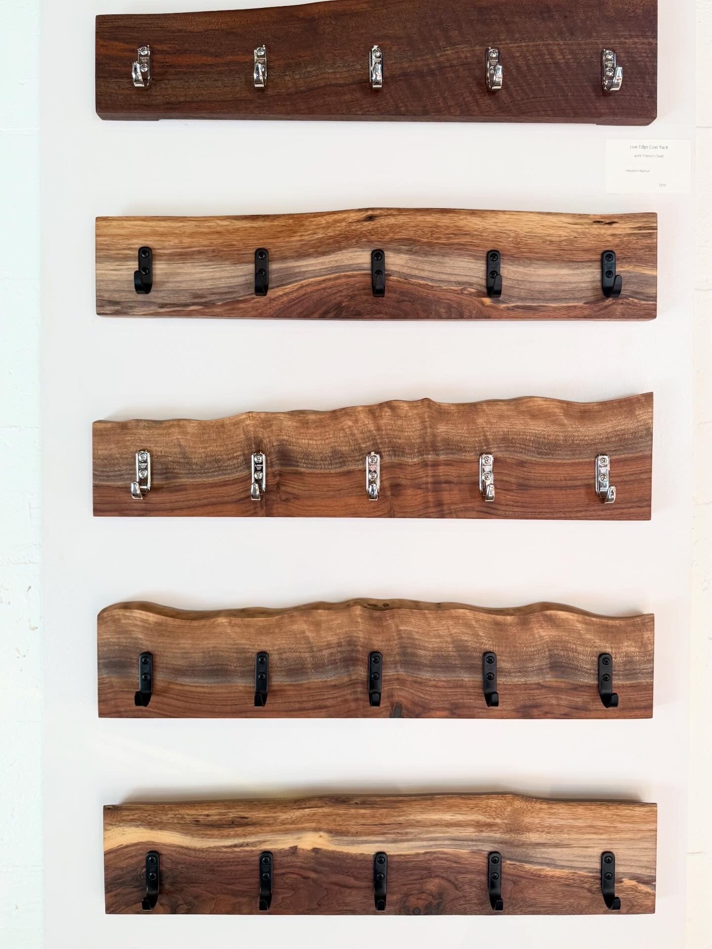Set of wooden wall coat racks with black and nickel hooks on a white background