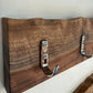 Wooden headboard with metal hooks on a neutral background