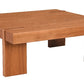 A low, square wooden table with thick block legs and visible wood grain, shown on a plain white background.