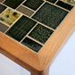 Tabletop with ceramic tiles featuring various patterns and colors on a wooden frame.