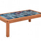 A rectangular wooden coffee table with a colorful mosaic tile top featuring shades of blue and teal, set against a plain white background.