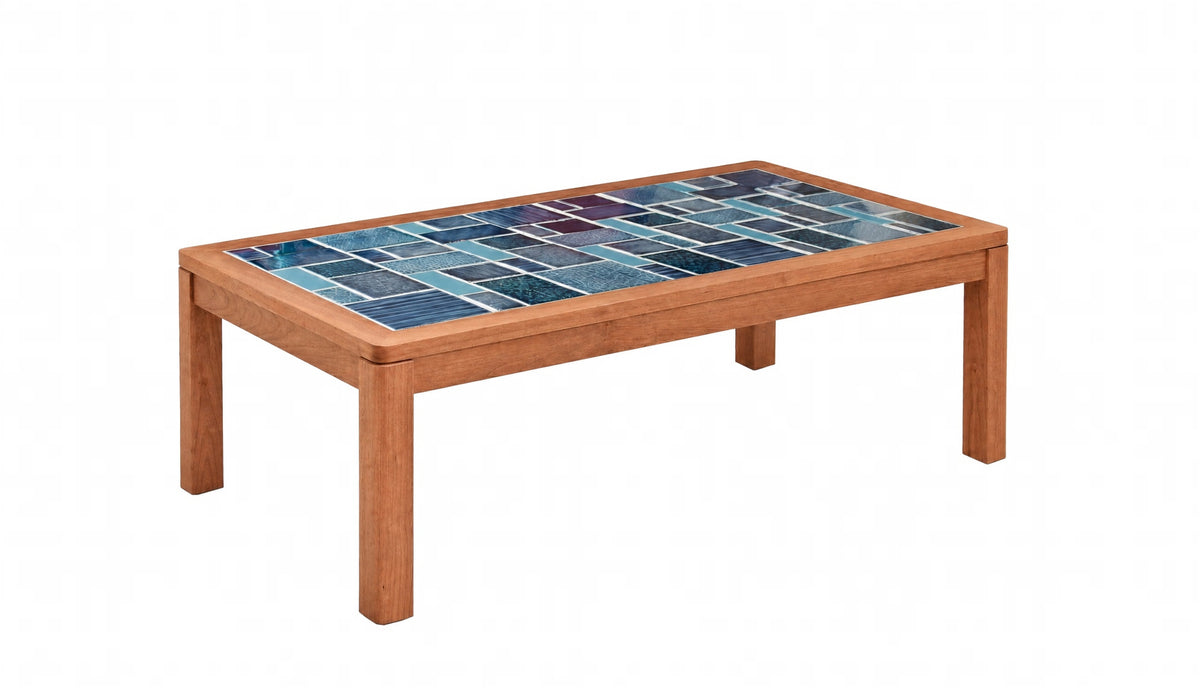A rectangular wooden coffee table with a colorful mosaic tile top featuring shades of blue and teal, set against a plain white background.