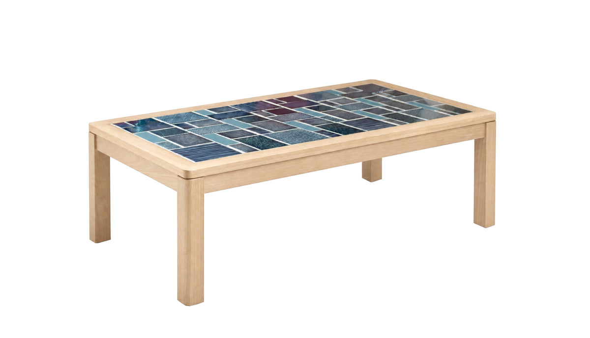 A rectangular wooden coffee table with a colorful mosaic tile top featuring shades of blue and teal, set against a plain white background.