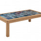 A rectangular wooden coffee table with a colorful mosaic tile top featuring shades of blue and teal, set against a plain white background.