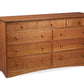 A wooden nine-drawer dresser with a warm Cherry finish and small round knobs, photographed on a plain white background.