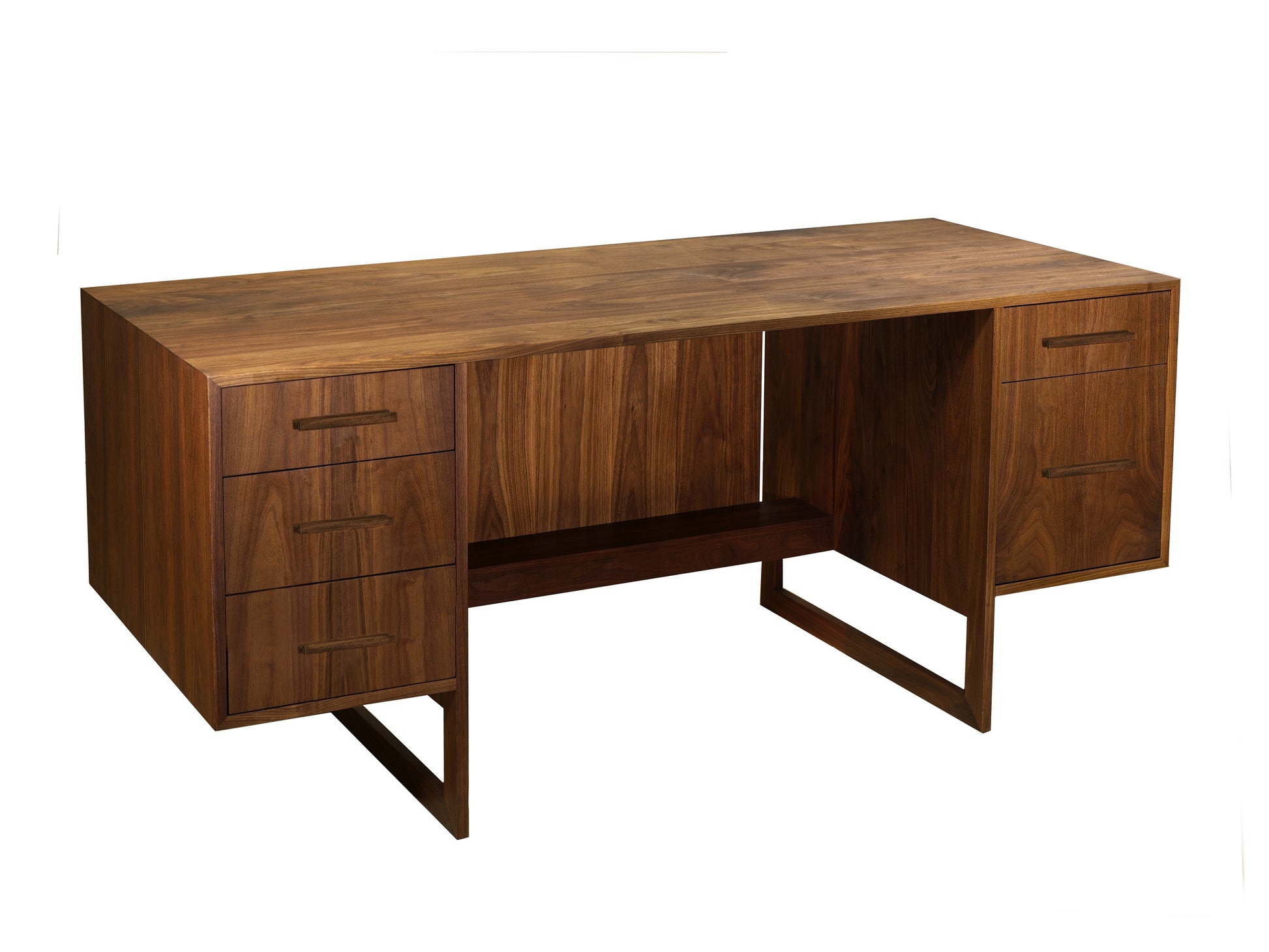 A mid-century modern walnut wood writing desk with three drawers on the left, two drawers on the right, an open center space, and a lower shelf, shown on a plain white background.