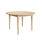 A light natural wood round dining table with four tapered legs, shown on a solid white background.