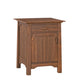 A small wooden nightstand with a medium brown finish, featuring a single drawer on top and a cabinet door below, shown against a plain white background.