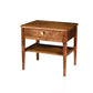 A mid-century modern wooden nightstand with a single drawer, open lower shelf, and a round brass knob, shown on a white background.