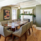 Dining room with wooden table and chairs, fireplace, and artwork on the wall.