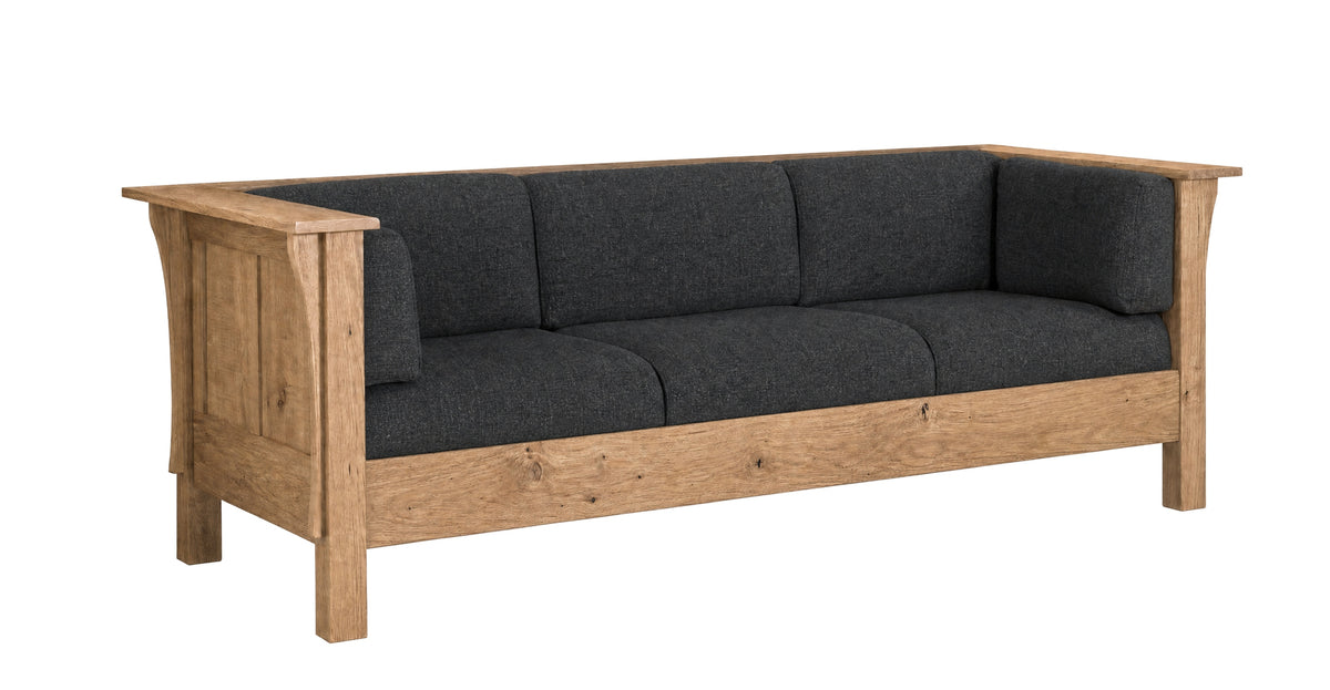 A rustic three-seater sofa with a natural oak wood frame and dark charcoal gray fabric cushions, shown from a three-quarter angle on a white background.