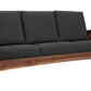 A three-seat wooden sofa with dark charcoal gray textured cushions and a medium brown wood frame, shown against a plain white background.