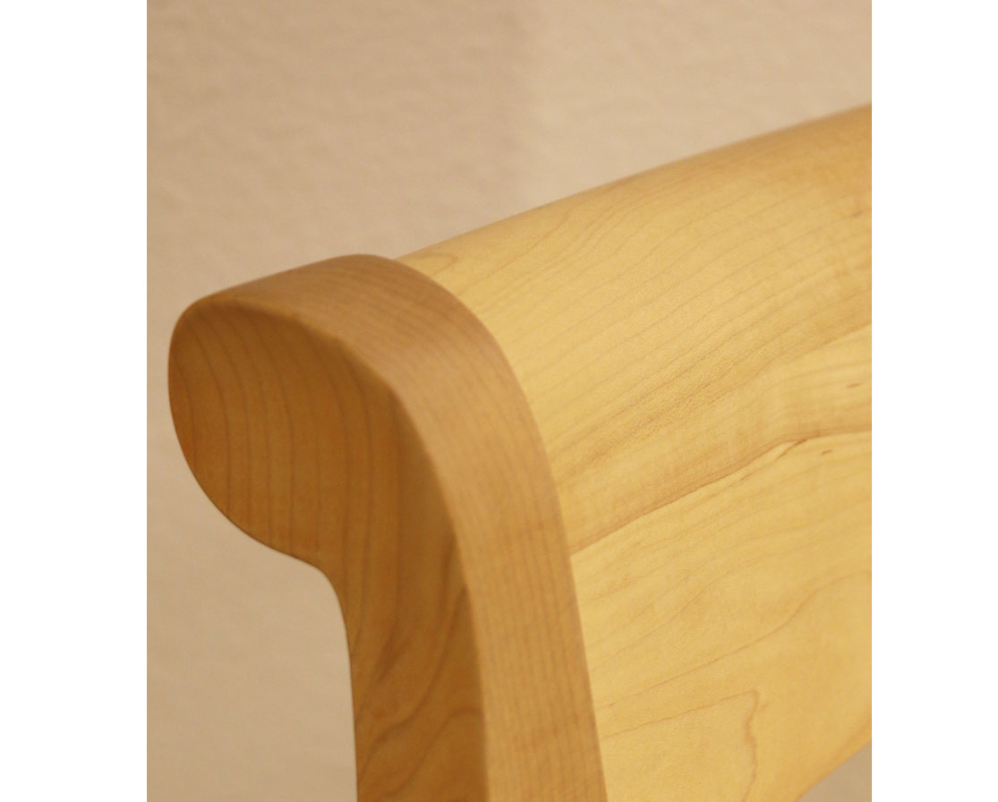 Wooden headboard against a beige wall