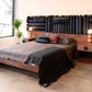 Bedroom with wooden bed and nightstands, colorful headboard, and decorative pillows.