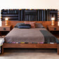 Wooden bed with patterned headboard and nightstands in a bedroom setting