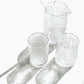 Set of textured glass tumblers and a pitcher on a white background