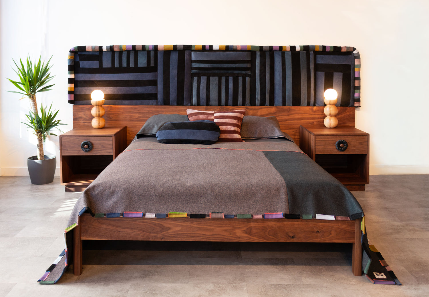 Wooden bed with patterned headboard and nightstands in a bedroom setting